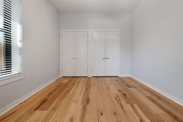 400 4th Ave S Unit 301, Saint Petersburg, FL 33701 - unfurnished bedroom with two closets, light wood-style flooring, multiple windows, and baseboards