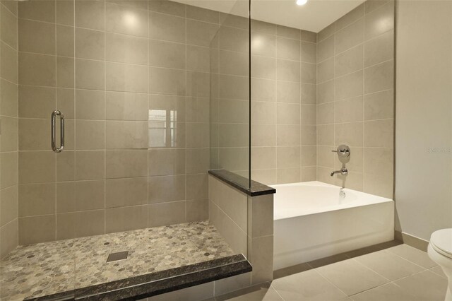 400 4th Ave S Unit 301, Saint Petersburg, FL 33701 - bathroom featuring tiled shower, tile patterned floors, toilet, a garden tub, and baseboards