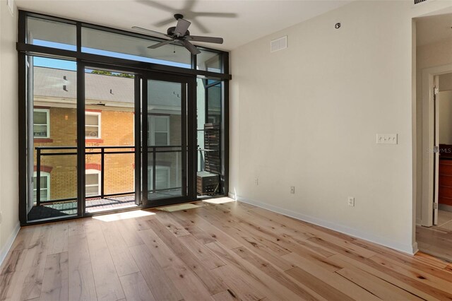 400 4th Ave S Unit 301, Saint Petersburg, FL 33701 - unfurnished room with wood finished floors, ceiling fan, baseboards, and expansive windows