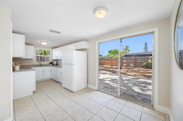 10599 111th Ave N, Largo, FL 33773 - kitchen with freestanding refrigerator, a sink, white cabinets, and light tile patterned floors
