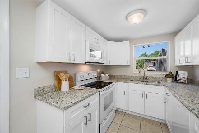 10599 111th Ave N, Largo, FL 33773 - kitchen featuring white appliances, a sink, white cabinetry, light tile patterned flooring, and light stone counters