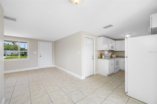 10599 111th Ave N, Largo, FL 33773 - kitchen featuring white appliances, light tile patterned floors, white cabinets, and baseboards