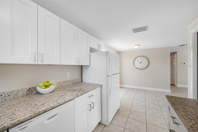 10599 111th Ave N, Largo, FL 33773 - kitchen featuring white appliances, white cabinetry, light tile patterned floors, and light stone countertops