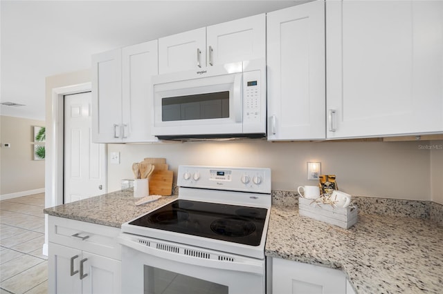 10599 111th Ave N, Largo, FL 33773 - kitchen featuring white appliances, white cabinets, light stone counters, and light tile patterned floors