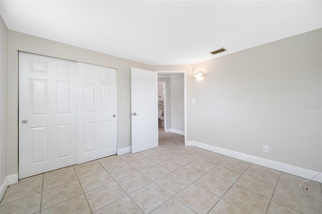 10599 111th Ave N, Largo, FL 33773 - unfurnished bedroom featuring a closet, light tile patterned floors, and baseboards
