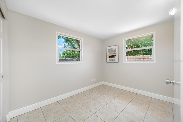 10599 111th Ave N, Largo, FL 33773 - empty room featuring plenty of natural light, light tile patterned floors, and baseboards