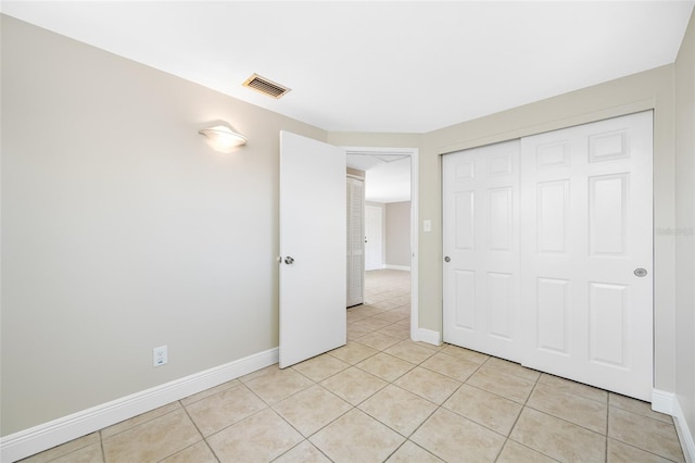 10599 111th Ave N, Largo, FL 33773 - unfurnished bedroom with light tile patterned floors, baseboards, and a closet