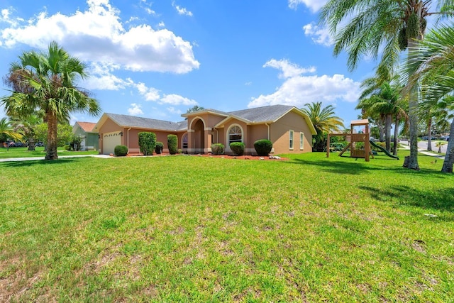 10228 Yellow Pine Way, Hudson, FL 34667 - ranch-style house featuring a garage, a playground, stucco siding, and a front yard