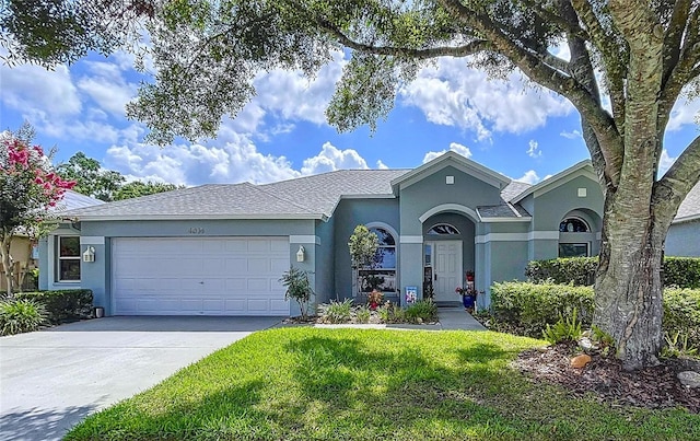 4315 Whittner Dr, Land O Lakes, FL 34639 - view of front facade with stucco siding, a garage, driveway, and a front yard