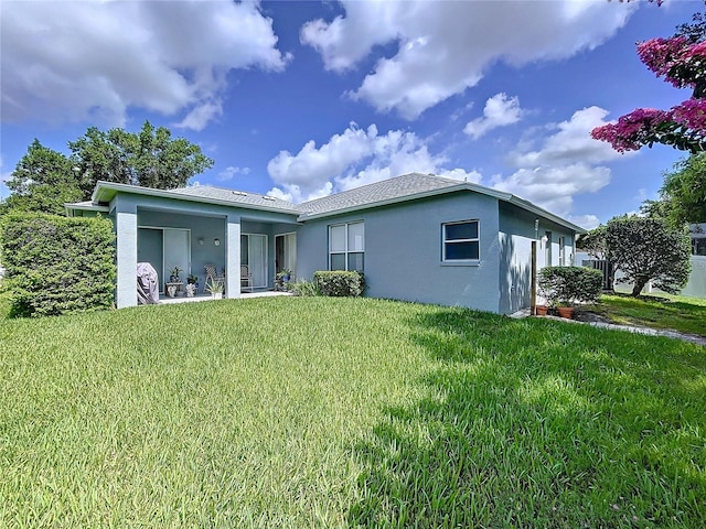 4315 Whittner Dr, Land O Lakes, FL 34639 - rear view of house with stucco siding and a lawn