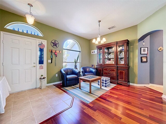 4315 Whittner Dr, Land O Lakes, FL 34639 - foyer entrance featuring arched walkways, light wood finished floors, and a chandelier