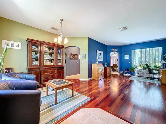 4315 Whittner Dr, Land O Lakes, FL 34639 - living room featuring arched walkways, a chandelier, and dark wood-style flooring