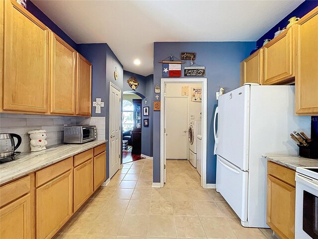 4315 Whittner Dr, Land O Lakes, FL 34639 - kitchen with washer and dryer, light tile patterned floors, recessed lighting, arched walkways, and light countertops