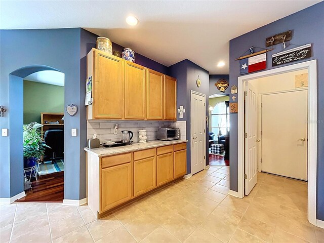 4315 Whittner Dr, Land O Lakes, FL 34639 - kitchen featuring arched walkways, light countertops, decorative backsplash, recessed lighting, and light tile patterned floors