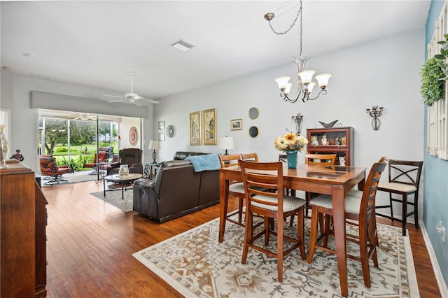 5143 Lochmead Ter, Zephyrhills, FL 33541 - dining area featuring wood finished floors, a chandelier, and a ceiling fan