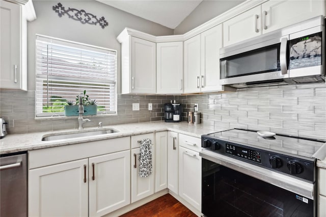 5143 Lochmead Ter, Zephyrhills, FL 33541 - kitchen with stainless steel appliances, backsplash, white cabinets, a sink, and lofted ceiling