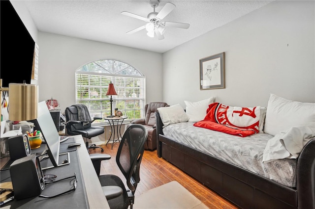 5143 Lochmead Ter, Zephyrhills, FL 33541 - bedroom featuring wood finished floors, a textured ceiling, a desk, and a ceiling fan