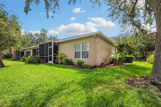 5143 Lochmead Ter, Zephyrhills, FL 33541 - rear view of property with stucco siding, a yard, and a sunroom