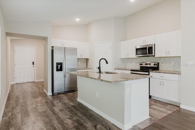 13016 Boggy Creek Dr, Riverview, FL 33579 - kitchen featuring stainless steel appliances, a sink, an island with sink, decorative backsplash, and high vaulted ceiling