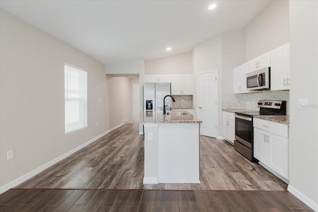 13016 Boggy Creek Dr, Riverview, FL 33579 - kitchen with appliances with stainless steel finishes, a sink, a kitchen island with sink, decorative backsplash, and lofted ceiling