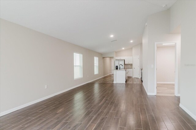 13016 Boggy Creek Dr, Riverview, FL 33579 - unfurnished living room with vaulted ceiling, dark wood finished floors, a sink, baseboards, and recessed lighting