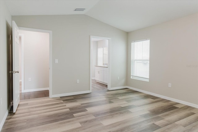 13016 Boggy Creek Dr, Riverview, FL 33579 - unfurnished bedroom with vaulted ceiling, light wood-style flooring, baseboards, and connected bathroom