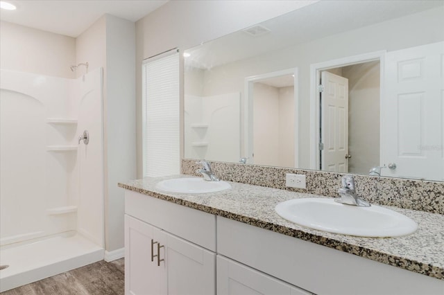 13016 Boggy Creek Dr, Riverview, FL 33579 - bathroom with double vanity, wood finished floors, and a shower