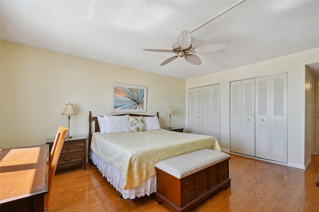 11000 Gulf Blvd Unit 703, Treasure Island, FL 33706 - bedroom featuring multiple closets, light wood finished floors, a ceiling fan, and a textured ceiling