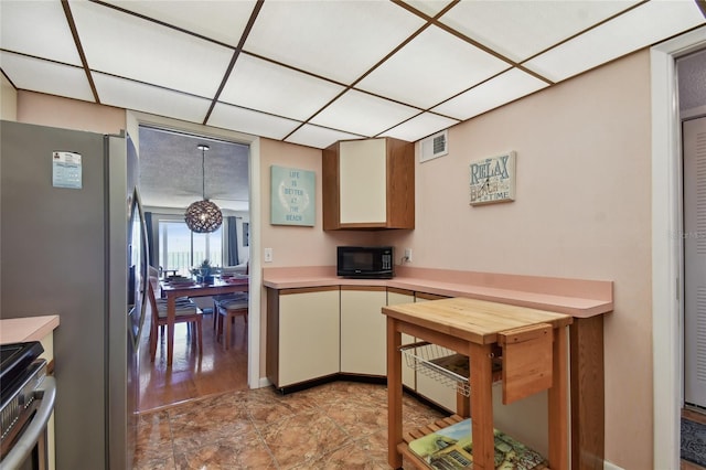 11000 Gulf Blvd Unit 703, Treasure Island, FL 33706 - kitchen featuring light countertops, appliances with stainless steel finishes, a paneled ceiling, and cream cabinets