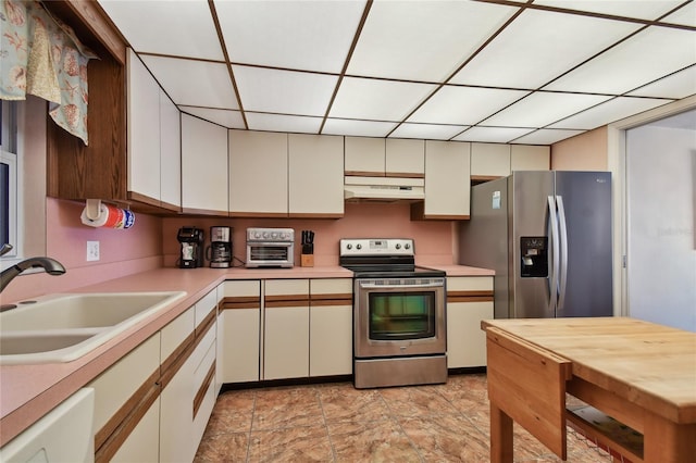 11000 Gulf Blvd Unit 703, Treasure Island, FL 33706 - kitchen featuring appliances with stainless steel finishes, a sink, under cabinet range hood, light countertops, and a drop ceiling