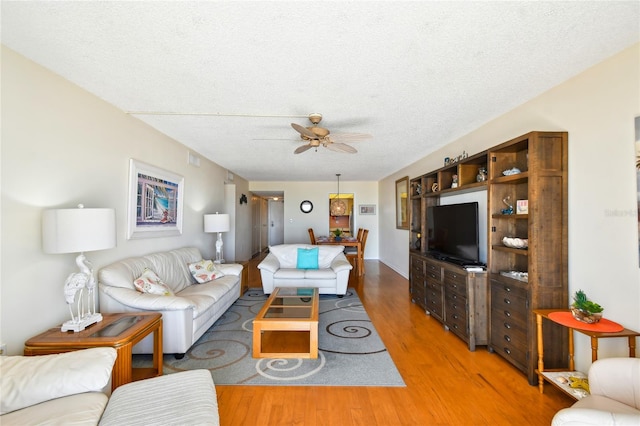 11000 Gulf Blvd Unit 703, Treasure Island, FL 33706 - living area featuring light wood-style flooring, a ceiling fan, and a textured ceiling