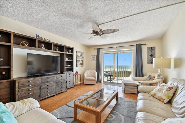 11000 Gulf Blvd Unit 703, Treasure Island, FL 33706 - living room with wood finished floors, a ceiling fan, and a textured ceiling
