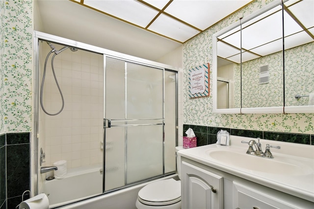 11000 Gulf Blvd Unit 703, Treasure Island, FL 33706 - bathroom with wallpapered walls, vanity, toilet, enclosed tub / shower combo, and wainscoting