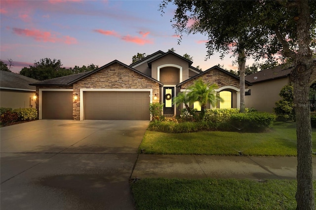 12729 Flatwood Creek Dr, Gibsonton, FL 33534 - single story home with stucco siding, stone siding, a garage, concrete driveway, and a front lawn