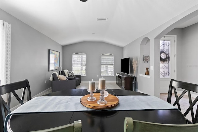 12729 Flatwood Creek Dr, Gibsonton, FL 33534 - dining area featuring vaulted ceiling, baseboards, and arched walkways
