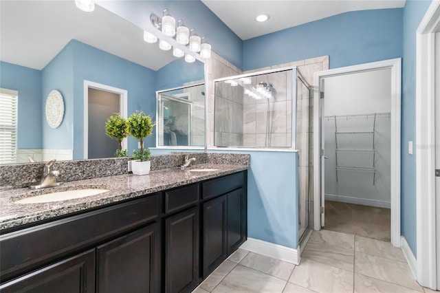 12729 Flatwood Creek Dr, Gibsonton, FL 33534 - full bath with a shower stall, double vanity, a walk in closet, and baseboards