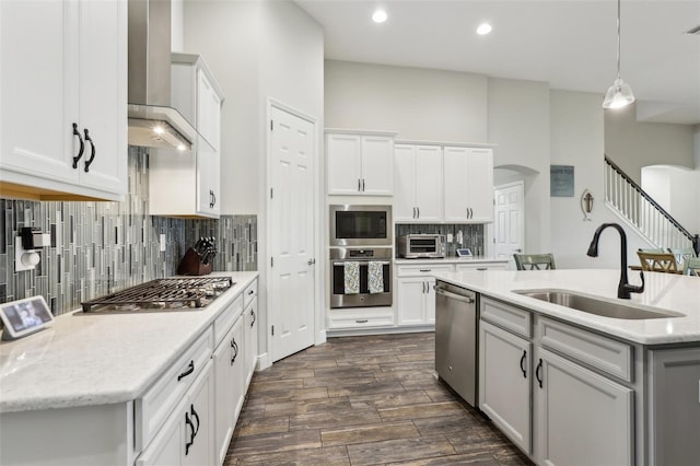 808 Vittorio Pl, Brandon, FL 33511 - kitchen featuring stainless steel appliances, a sink, arched walkways, wall chimney range hood, and dark wood-type flooring