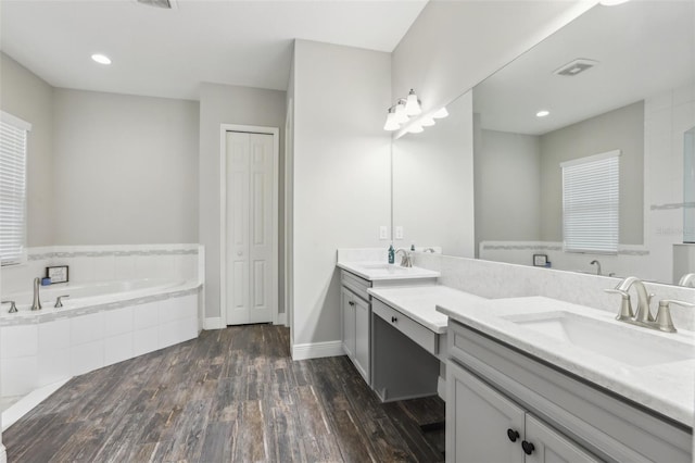 808 Vittorio Pl, Brandon, FL 33511 - bathroom with double vanity, a garden tub, wood finished floors, baseboards, and recessed lighting