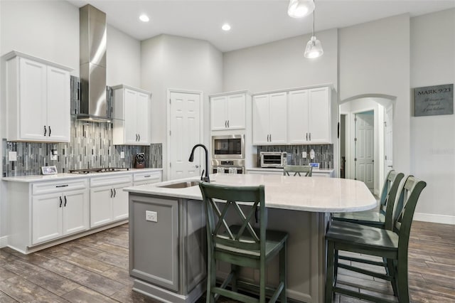808 Vittorio Pl, Brandon, FL 33511 - kitchen with a sink, dark wood-type flooring, wall chimney exhaust hood, white cabinets, and backsplash