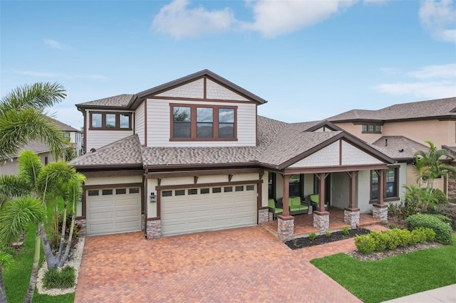 808 Vittorio Pl, Brandon, FL 33511 - craftsman-style house with decorative driveway, a garage, a shingled roof, and stone siding