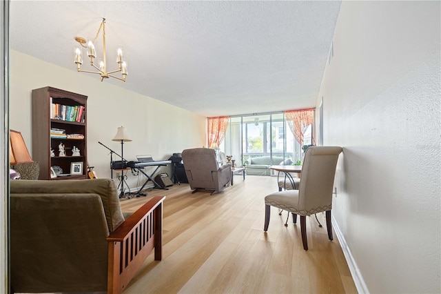 19029 US Highway 19 N Unit 3-1, Clearwater, FL 33764 - living area with light wood-style flooring, a chandelier, a wall of windows, baseboards, and a textured ceiling