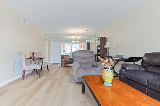 19029 US Highway 19 N Unit 3-1, Clearwater, FL 33764 - living area featuring light wood-style floors, a chandelier, baseboards, and a textured ceiling