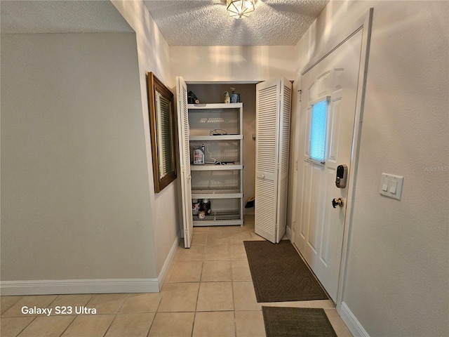 2221 Norwegian Dr Unit 15, Clearwater, FL 33763 - corridor featuring light tile patterned floors, a textured ceiling, and baseboards