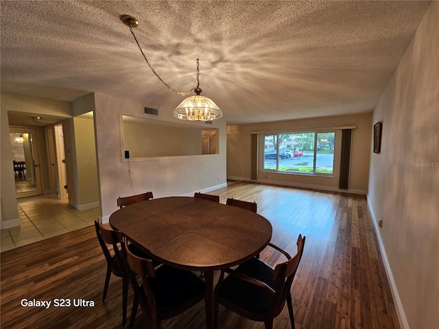 2221 Norwegian Dr Unit 15, Clearwater, FL 33763 - dining space with a chandelier, hardwood / wood-style flooring, baseboards, and a textured ceiling