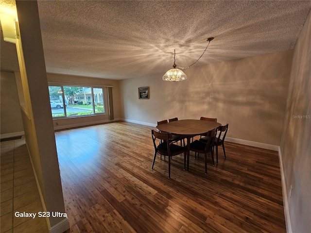2221 Norwegian Dr Unit 15, Clearwater, FL 33763 - dining room featuring dark wood-style floors, a chandelier, a textured ceiling, and baseboards