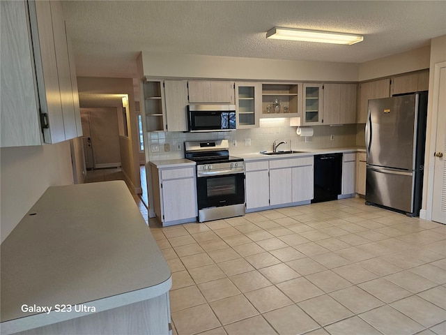 2221 Norwegian Dr Unit 15, Clearwater, FL 33763 - kitchen featuring appliances with stainless steel finishes, open shelves, a sink, light countertops, and a textured ceiling
