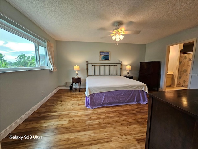 2221 Norwegian Dr Unit 15, Clearwater, FL 33763 - bedroom with wood finished floors, a textured ceiling, baseboards, a ceiling fan, and ensuite bathroom