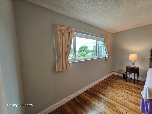 2221 Norwegian Dr Unit 15, Clearwater, FL 33763 - spare room with a textured ceiling, baseboards, and wood finished floors
