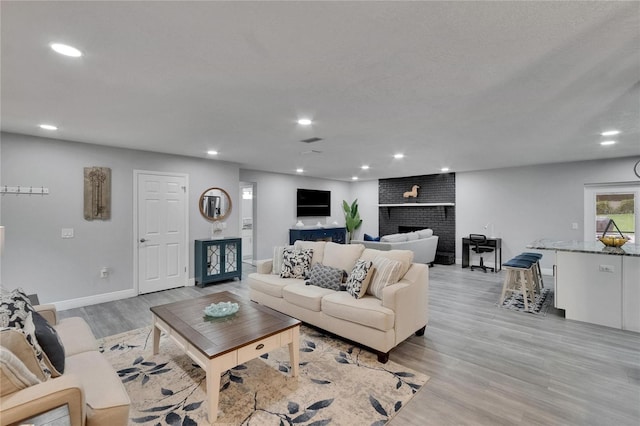 8222 Valrie Ln, Riverview, FL 33569 - living area featuring light wood finished floors, recessed lighting, baseboards, and a fireplace