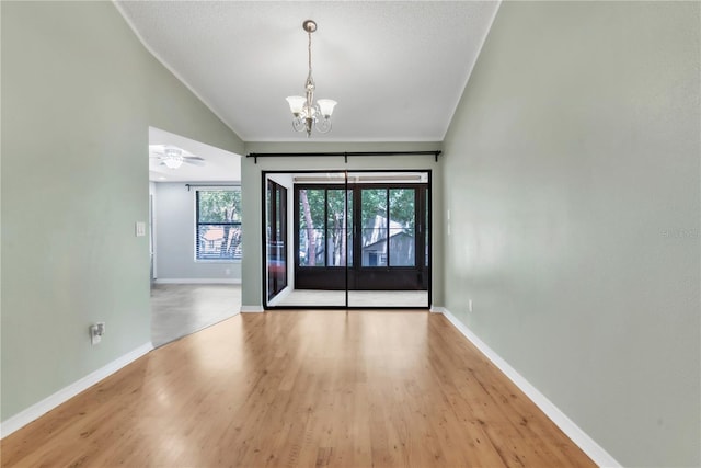 2640 Enterprise Rd E Unit B25, Clearwater, FL 33759 - empty room with vaulted ceiling, a chandelier, light wood-type flooring, and baseboards